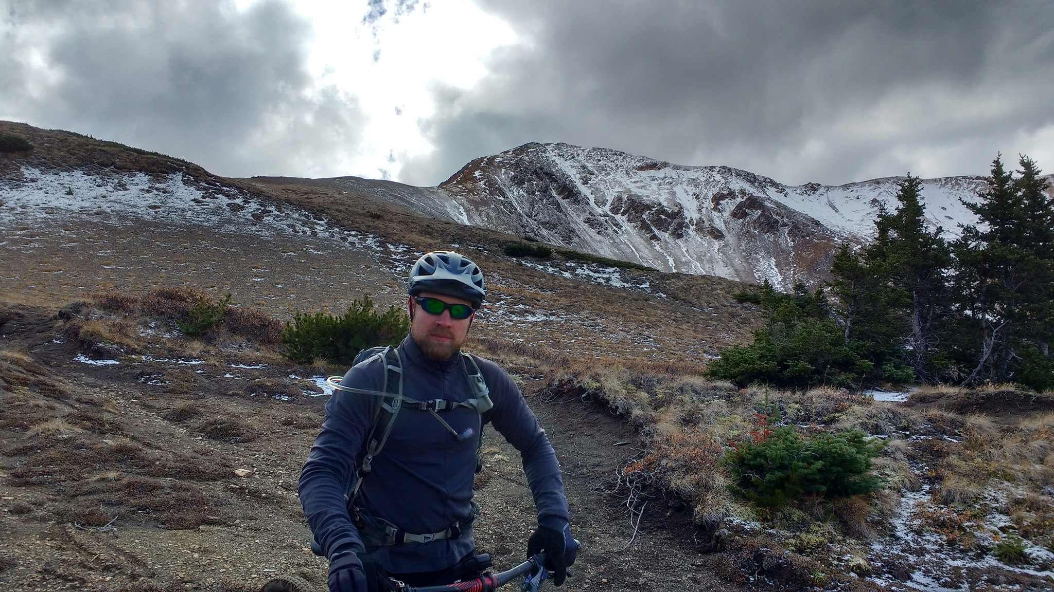 Greg with a snow covered peak behind him